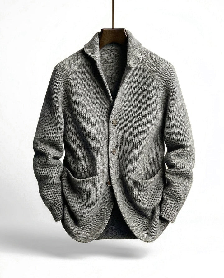 Gray version of the ribbed cardigan with three buttons and two front pockets, hanging on a wooden hanger 4