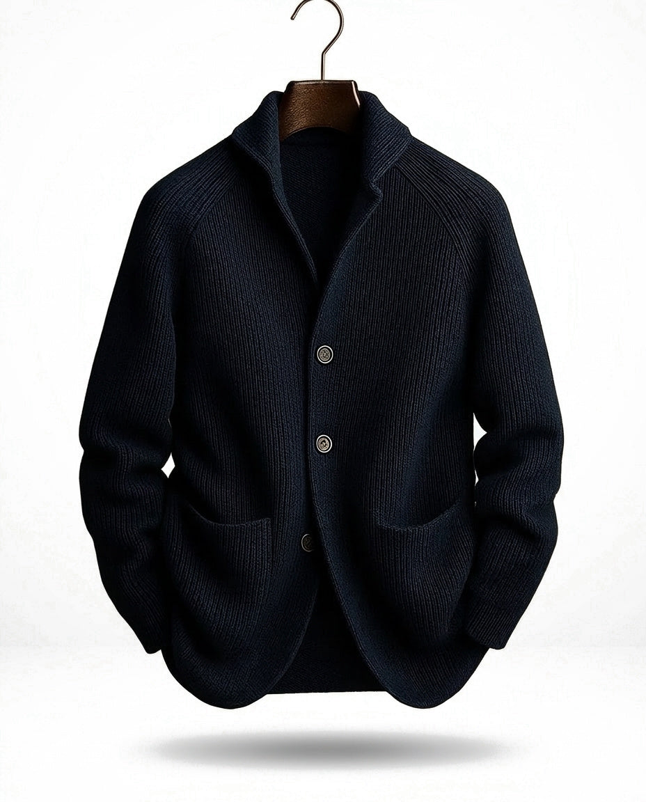 Dark navy version of the ribbed cardigan on a hanger with a metal hook against a white backdrop 3