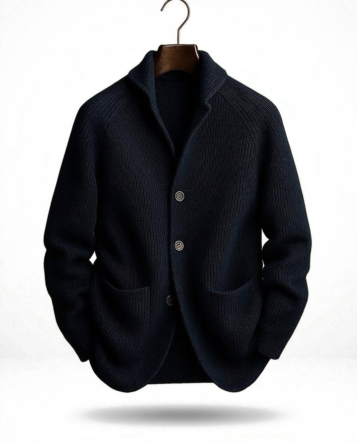 Dark navy version of the ribbed cardigan on a hanger with a metal hook against a white backdrop 3