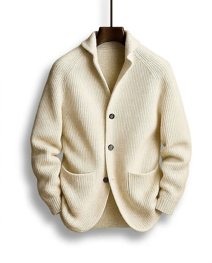 Cream version of the ribbed cardigan with dark buttons and a shawl collar, hanging on a wooden hanger 5