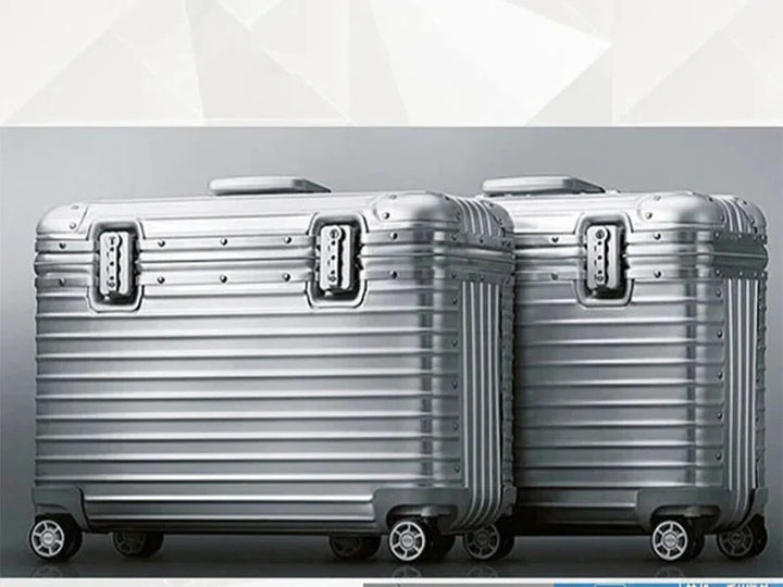 Two silver grooved suitcases with riveted trim and twin latches shown side by side on a gray backdrop 5