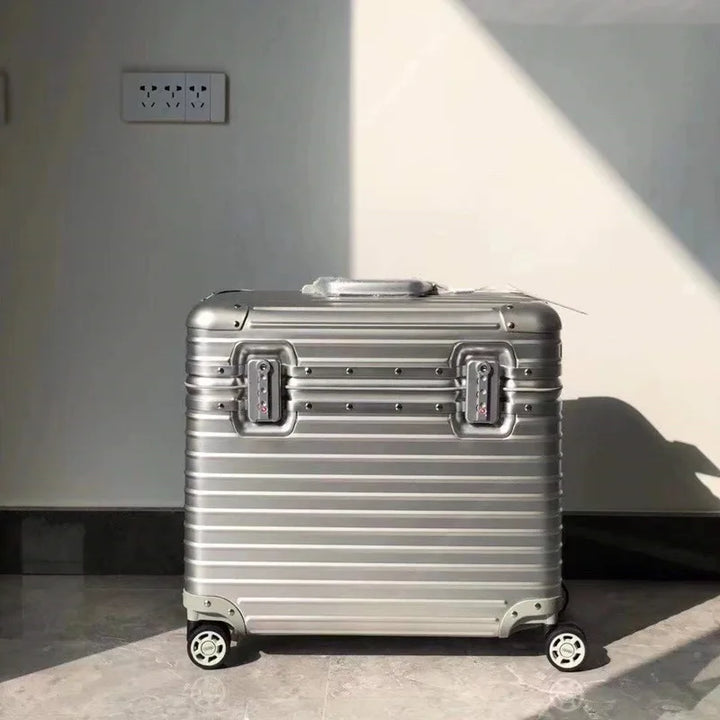 Front view of a silver grooved suitcase with two combination locks standing in a sunlit room 8