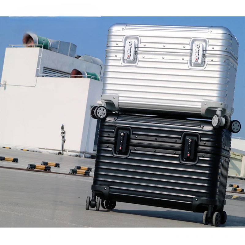 Silver and black ribbed cases stacked on a rooftop under a blue sky, wheels visible 2