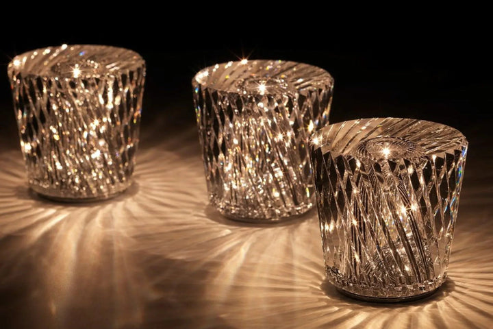 Gold transparent crystal table lamp, another view, with three spiral-cut lamps glowing in a row.