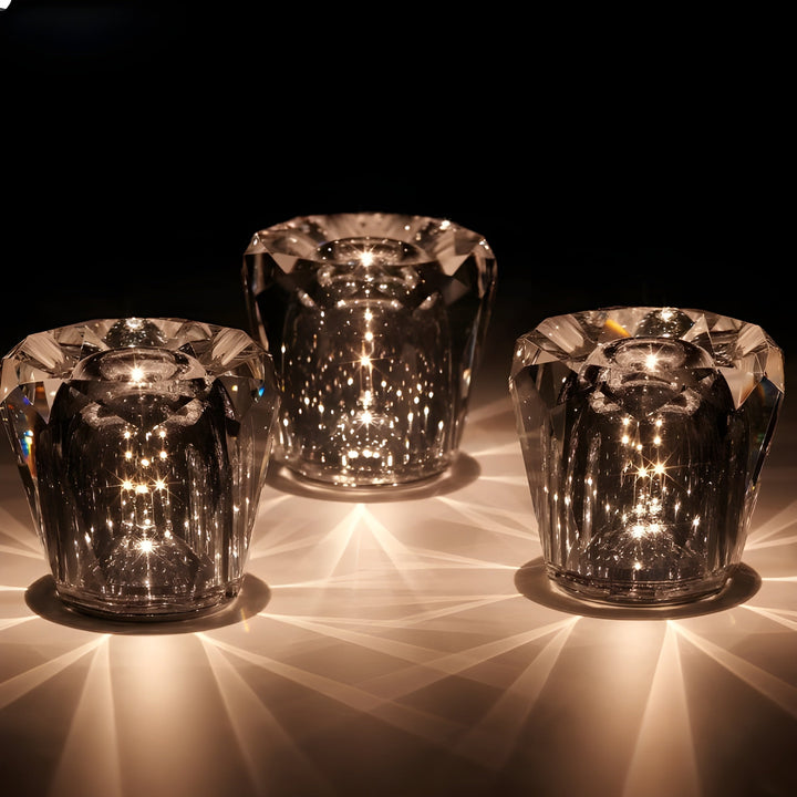 Gold transparent crystal table lamp, another view, with three diamond-topped lamps glowing against a black backdrop.