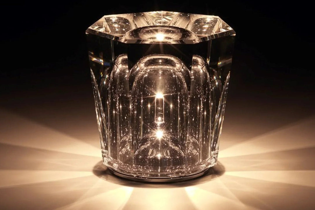 Gold transparent crystal table lamp, another view, glowing amber on a dark background.