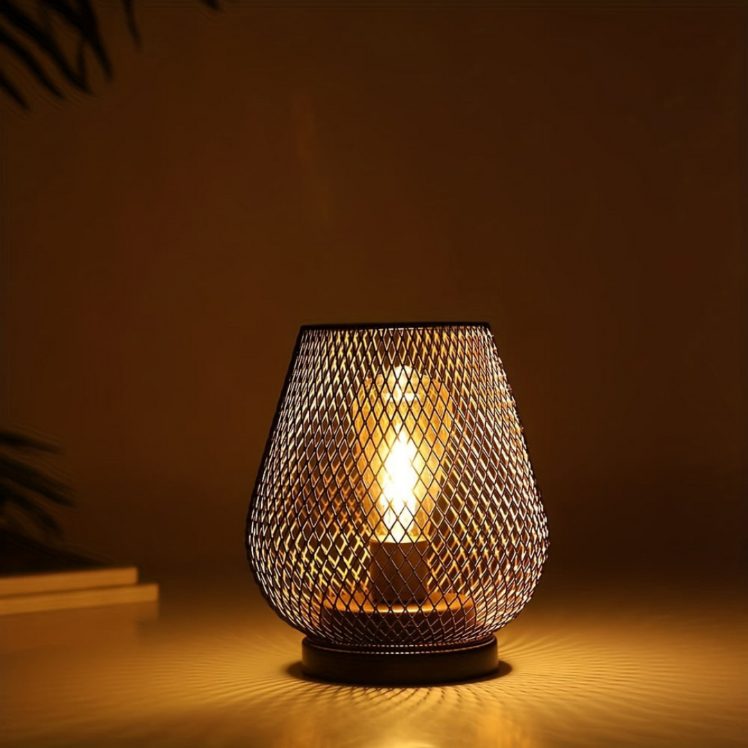 Single lit mesh lantern in a dark room, casting a diamond-patterned glow across the surface beneath it. 2