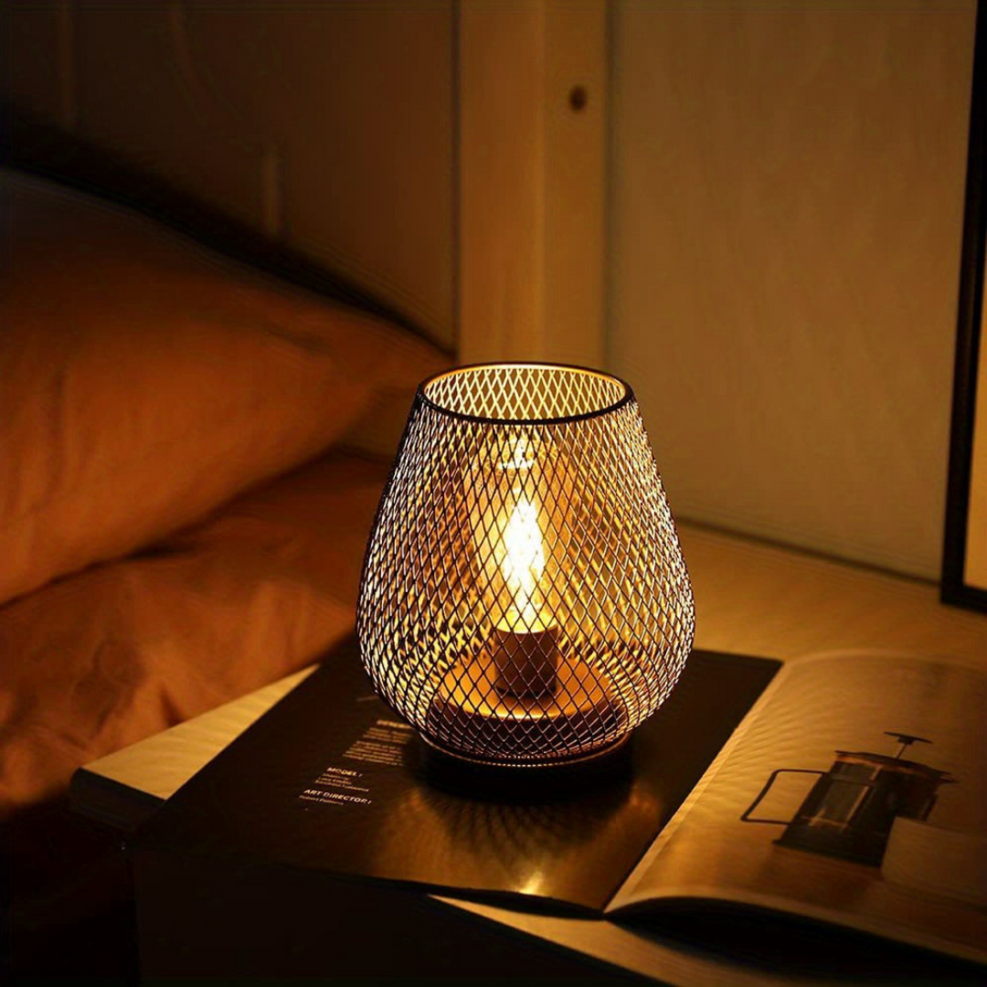 One lit mesh lantern on a nightstand by a bed in a dim room, resting on an open magazine. 8
