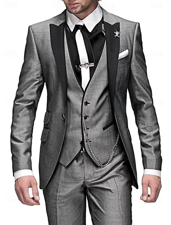 Men's three-piece suit in shimmery gray with black peak lapels, white tie, tie clip and silver vest chain.