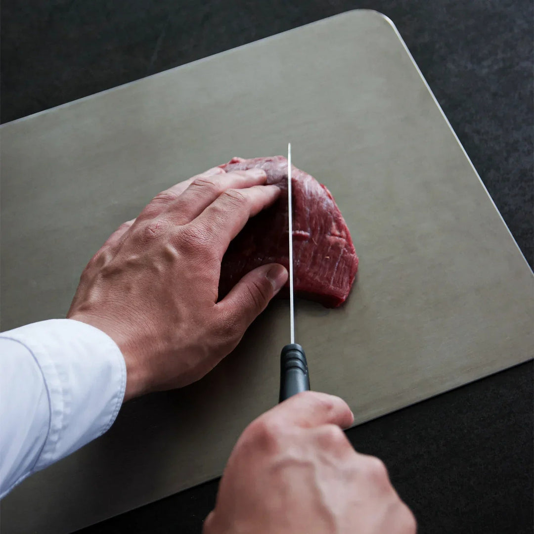Titan Kitchen Cutting Board detail showing use with raw meat and a black-handled knife