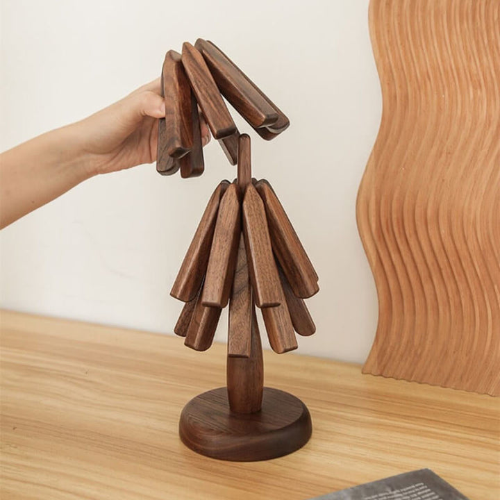 Black walnut wood table mat with the folded slats lifted from the tree-shaped stand