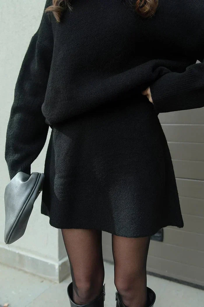 Detail of the black flared knit skirt, worn with the sweater, sheer tights and black boots 7