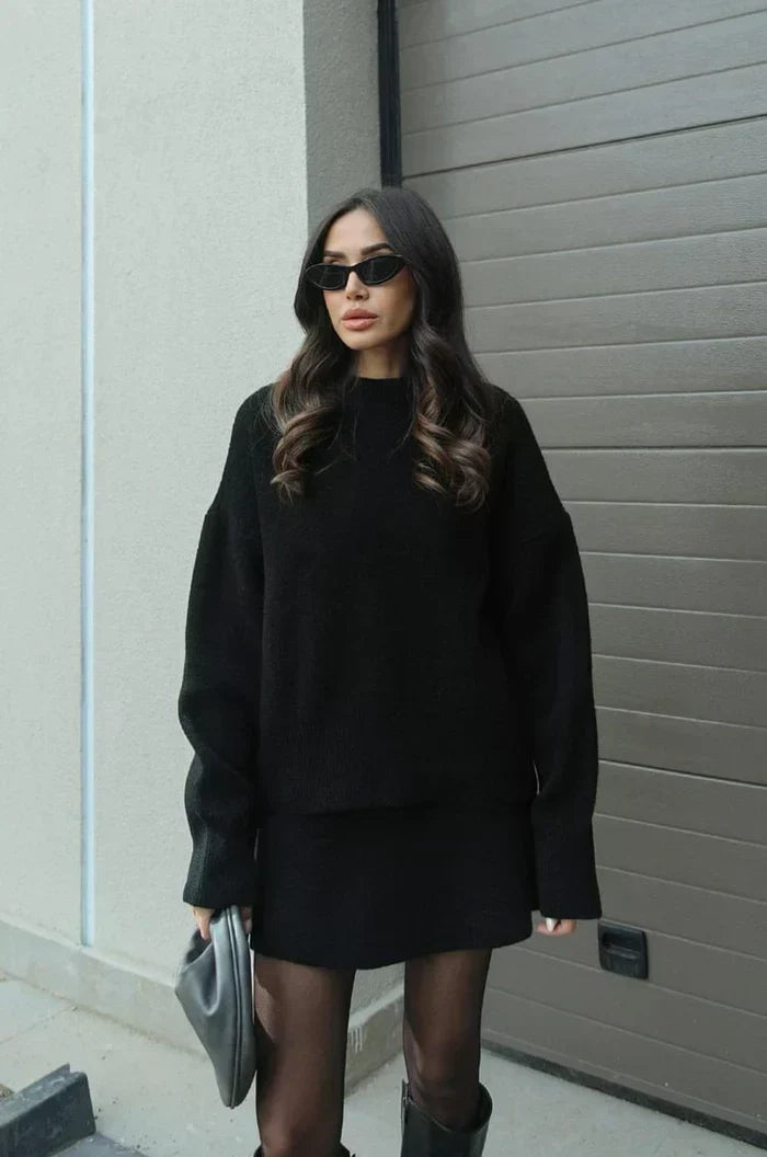 Black oversized knit sweater and mini skirt styled with sheer tights, tall boots and a gray clutch 5