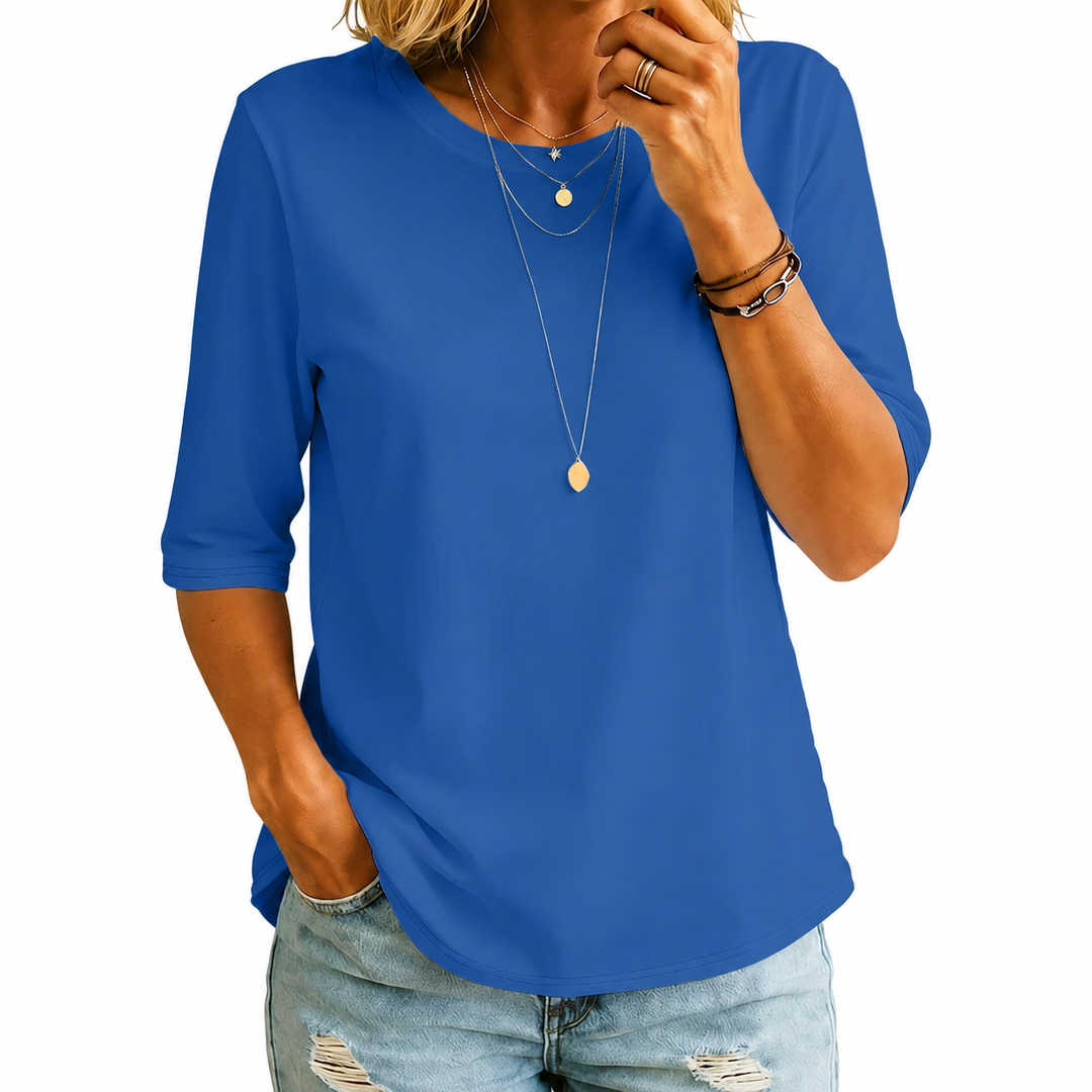 Woman wearing the royal blue crew-neck tee with longer half sleeves and a curved hem, another view.