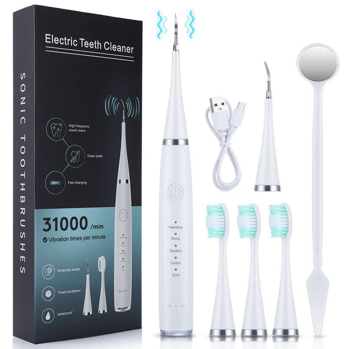 White set laid out with its black box, scaler handle, three brush heads, extra scaler tip, USB charging cable and dental mirror.