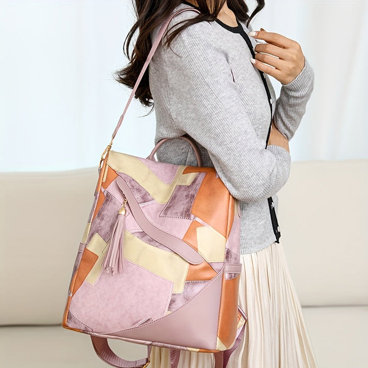 Woman carrying the pink and orange patchwork bag on one shoulder by its long strap, wearing a gray cardigan and pleated skirt. 9