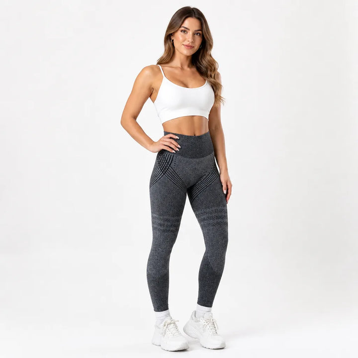 Model posing in dark gray heathered leggings with black sculpting lines and thigh bands, paired with a white sports bra. 14