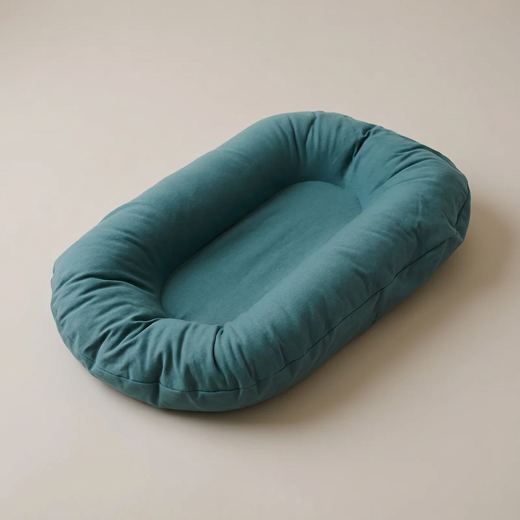Empty teal oval lounger with raised padded edges, seen from above at an angle 1