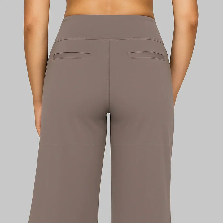 Women's taupe-brown pants back view showing the wide waistband, center back seam and two welt pockets, with the wide legs below.