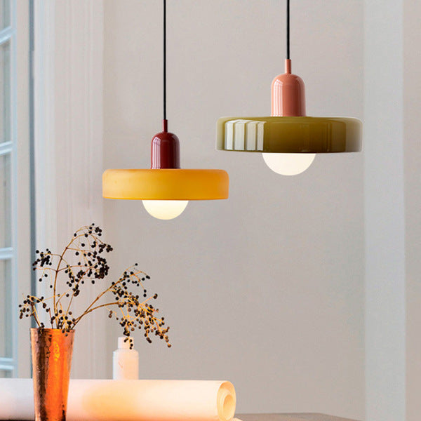 Two pendants hung together near a window: an amber shade with burgundy cap and an olive shade with pink cap. 38