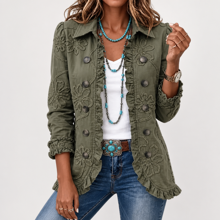 Green floral embroidered utility jacket detail with floral embroidery, ruffle trim and buttons styled with layered turquoise necklaces.