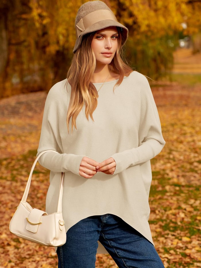 Frau im cremefarbenen Pullover und Hut, Herbstmode, beige Handtasche, lässiger Stil.