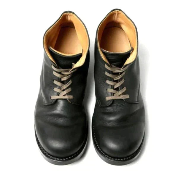 Men's black leather lace-up boots with tan laces and tan lining, detail.