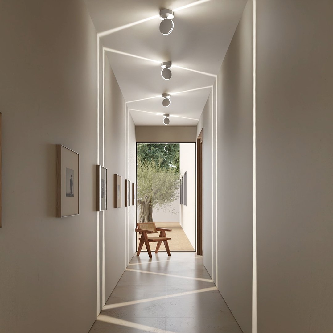 White LED wall sconce another view showing angled fixtures projecting light lines across the hallway.