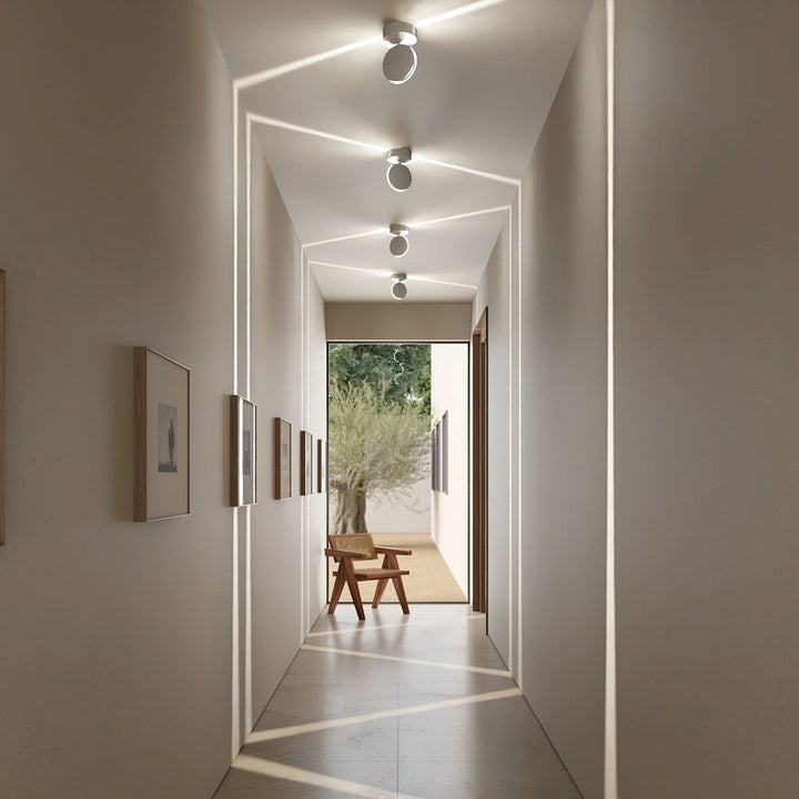 White LED wall sconce another view showing angled fixtures projecting light lines across the hallway.