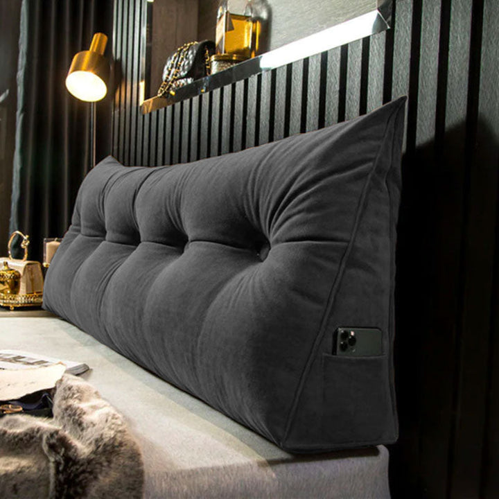 another view of a dark charcoal gray tufted velvet wedge pillow with a phone in the side pocket.