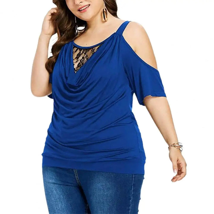 Frau in blauer Cold-Shoulder-Bluse mit Spitzenakzent, lässige Mode, Plus-Size, Jeans.
