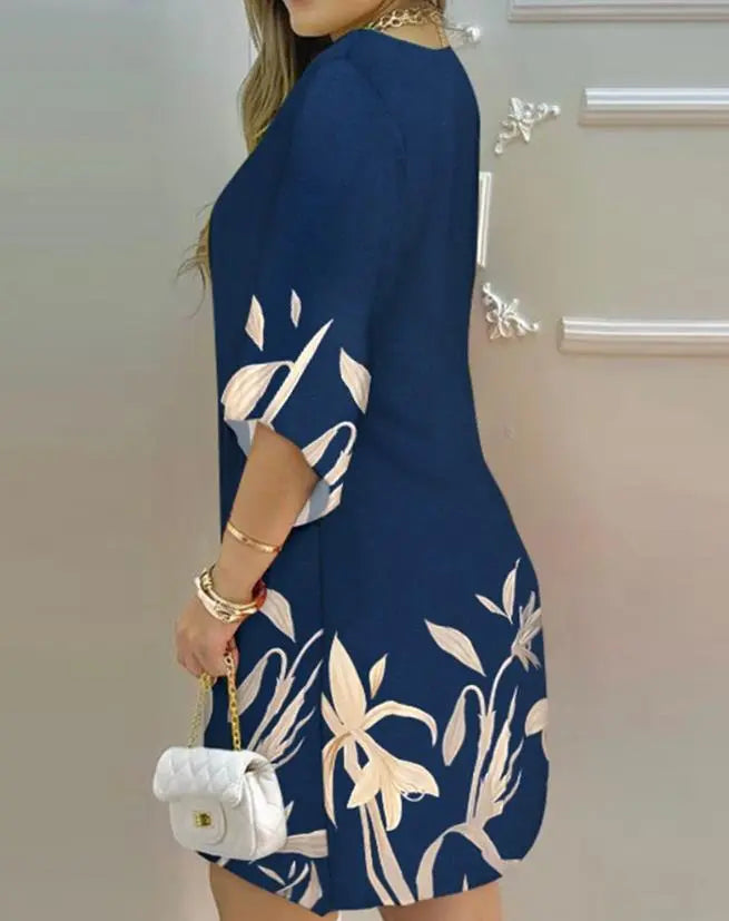 Damenkleid blau mit Blumenmuster, 3/4-Ärmel, elegante Mode, Handtasche, Rückansicht.