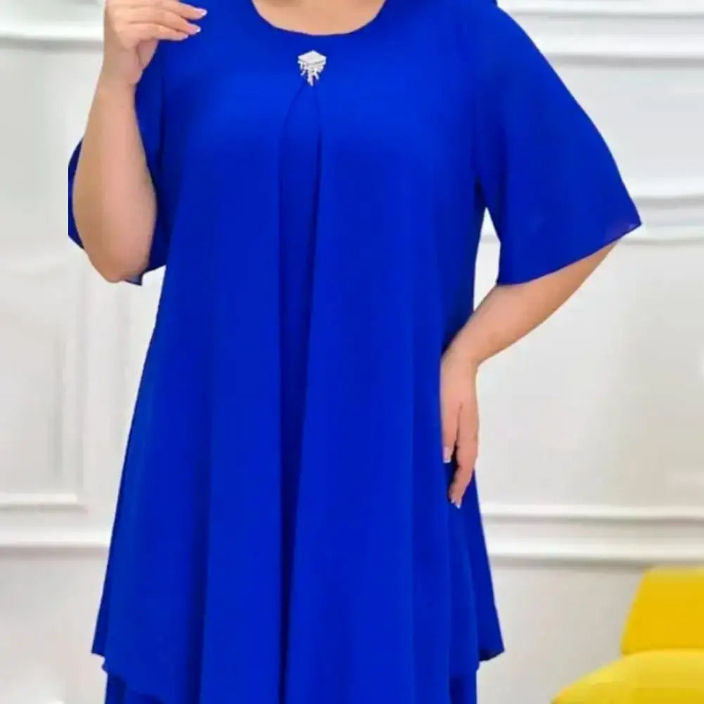 Frau in blauem Kleid mit Brosche, elegantes Design, Kurzarm, Mode für besondere Anlässe.