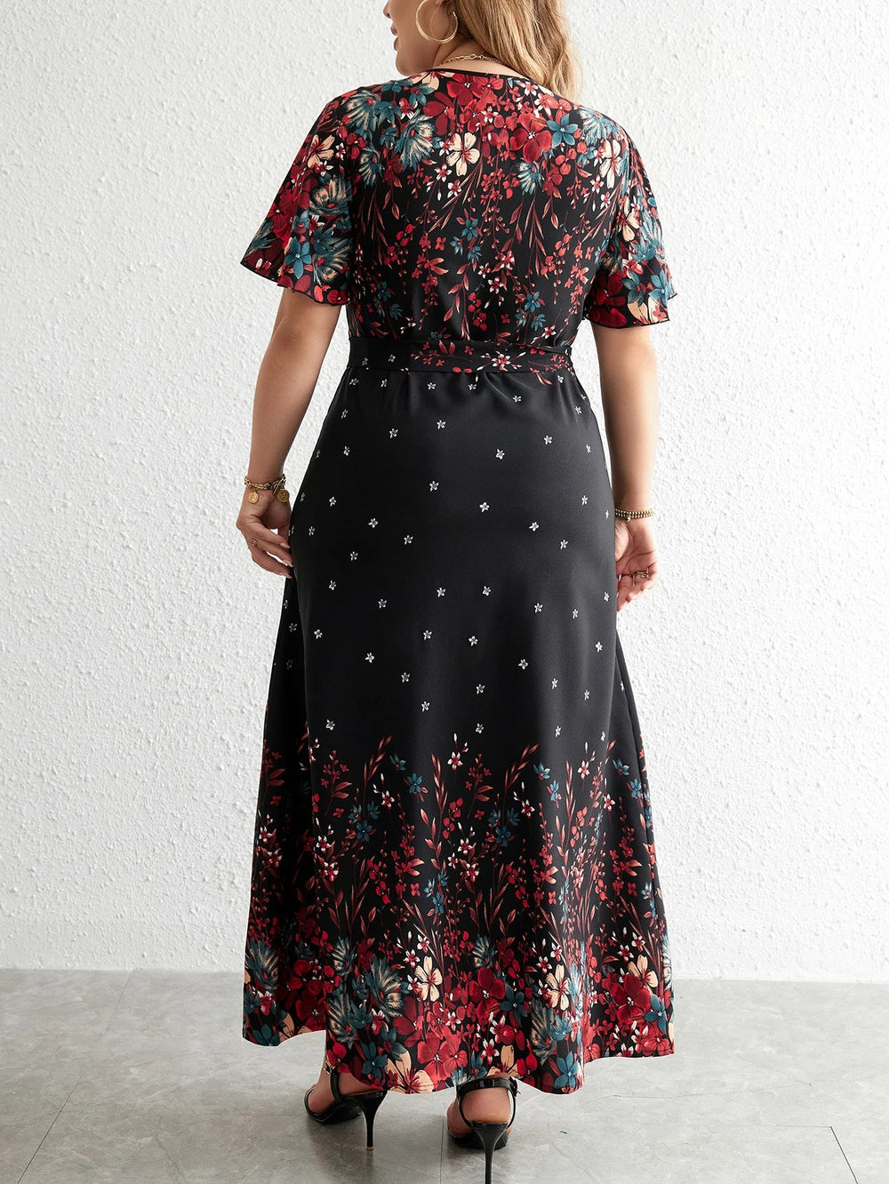 Frau in langem, geblümtem Kleid, schwarz-rot, Rückansicht, elegantes Design, Mode.