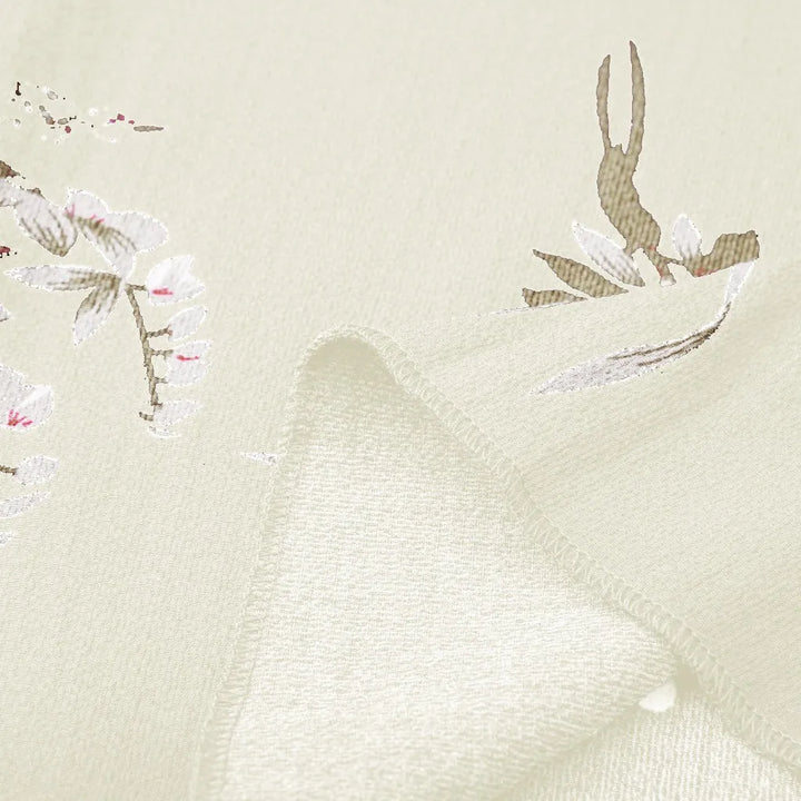 Beige Stoff mit floralen Mustern, weiche Textur, ideal für Bekleidung und Dekoration.