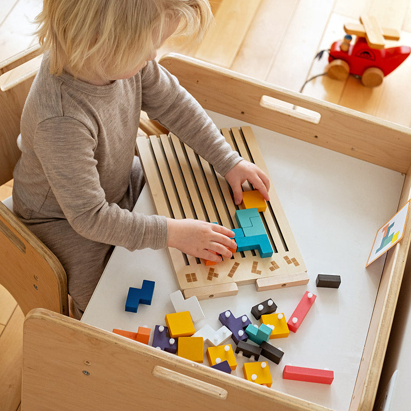 Wooden Tetris puzzle game another view of a toddler assembling blocks at a wooden table