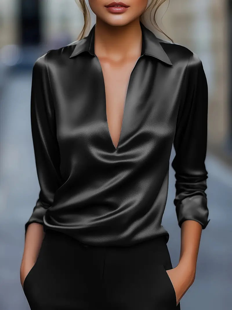 Model wearing the long-sleeve satin blouse in black with a glossy sheen, deep V-neckline and collar.