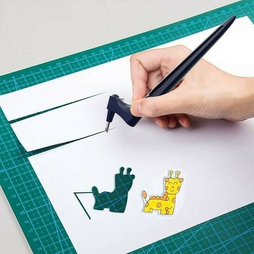 Hand guiding the navy swivel-blade knife along white paper on a green mat, with a giraffe cutout and sticker beside it. 2