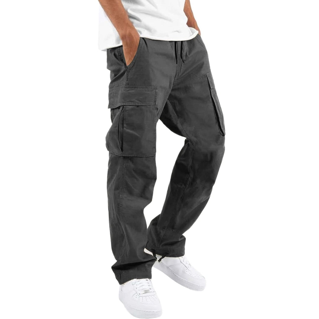 Model wearing dark gray cargo pants with white tee and white sneakers, hand in pocket, angled side view. 8