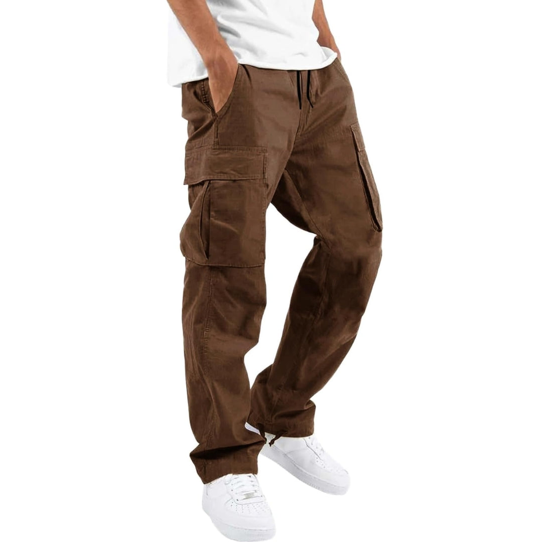 Model wearing brown cargo pants with white tee and white sneakers, hand in pocket, angled side view. 5
