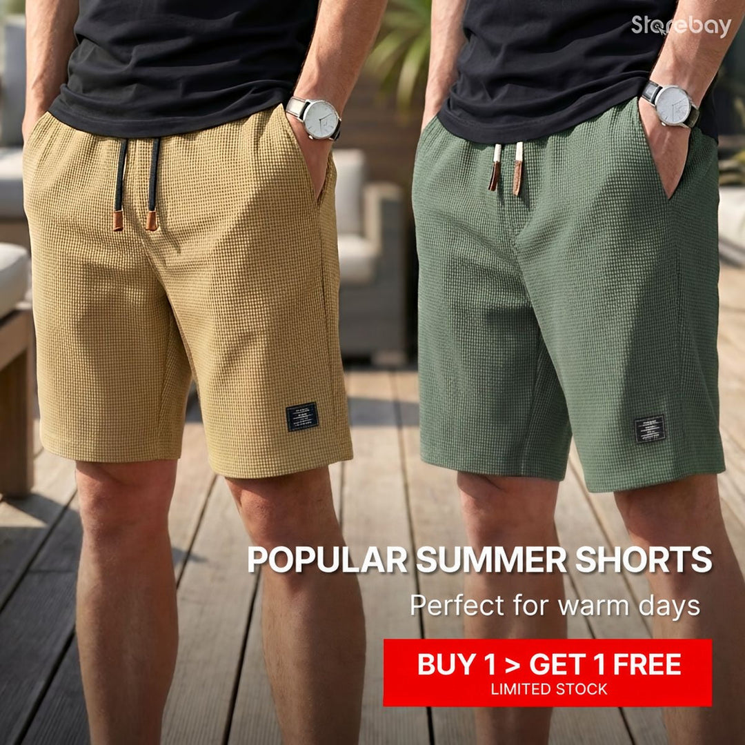 Two models side by side on a wooden deck wearing waffle-knit shorts in tan and green, hands in pockets 1