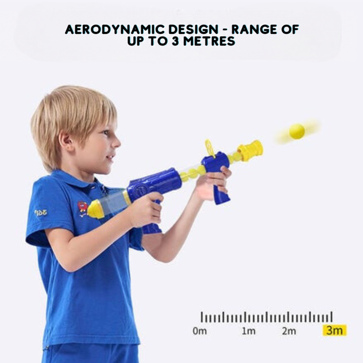 Boy in a blue shirt fires the blaster, a foam ball in flight beside a distance scale 9