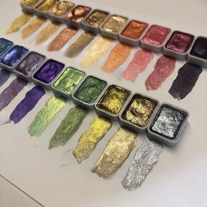 Detail of two rows of metallic paint pans from gold to purple, green and silver, each with a glittering swatch.