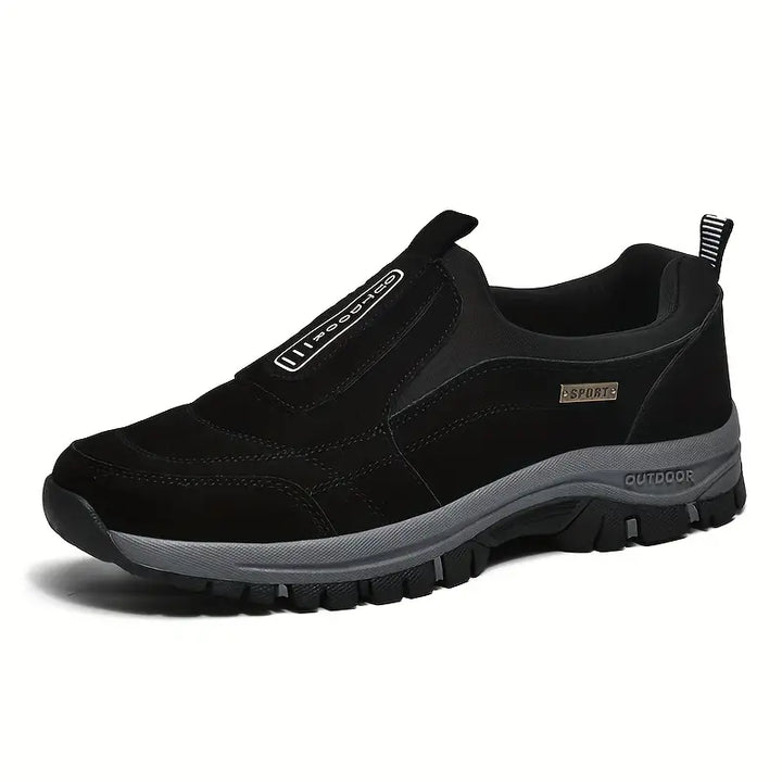 Side view of the slip-on shoe in solid black, showing the stitched upper, elastic gusset and a gray sole with deep tread. 3