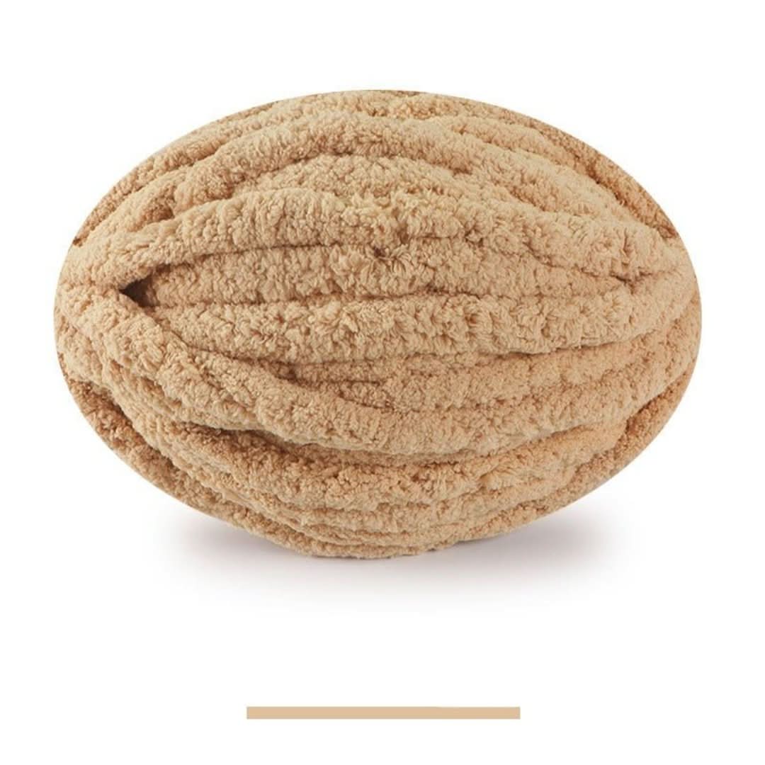 Single oval skein of light camel tan chunky yarn on a white background, with a color swatch bar below.
