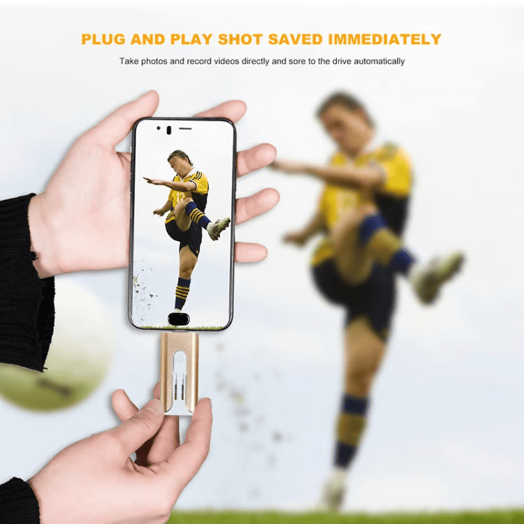 Two hands holding a phone with a gold drive attached, its screen showing a soccer player kicking a ball.