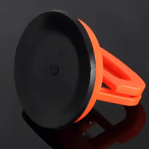 Detail of an orange suction puller showing the flat black rubber suction face and the handle folded to the side.