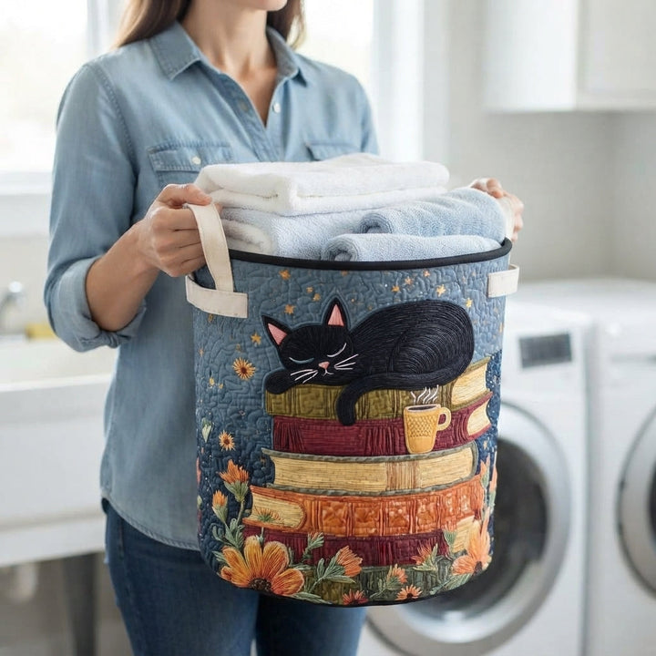 Quilted Cat Library Laundry Basket with Handles in a detail view, carried by its handle and filled with folded towels.