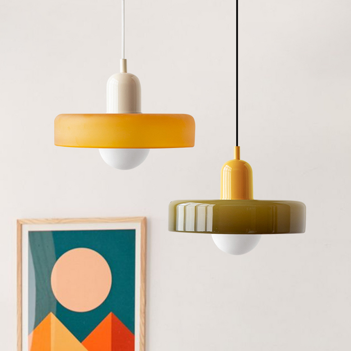 Two pendants hanging beside a framed geometric print: amber with cream cap, olive glass with yellow cap 27