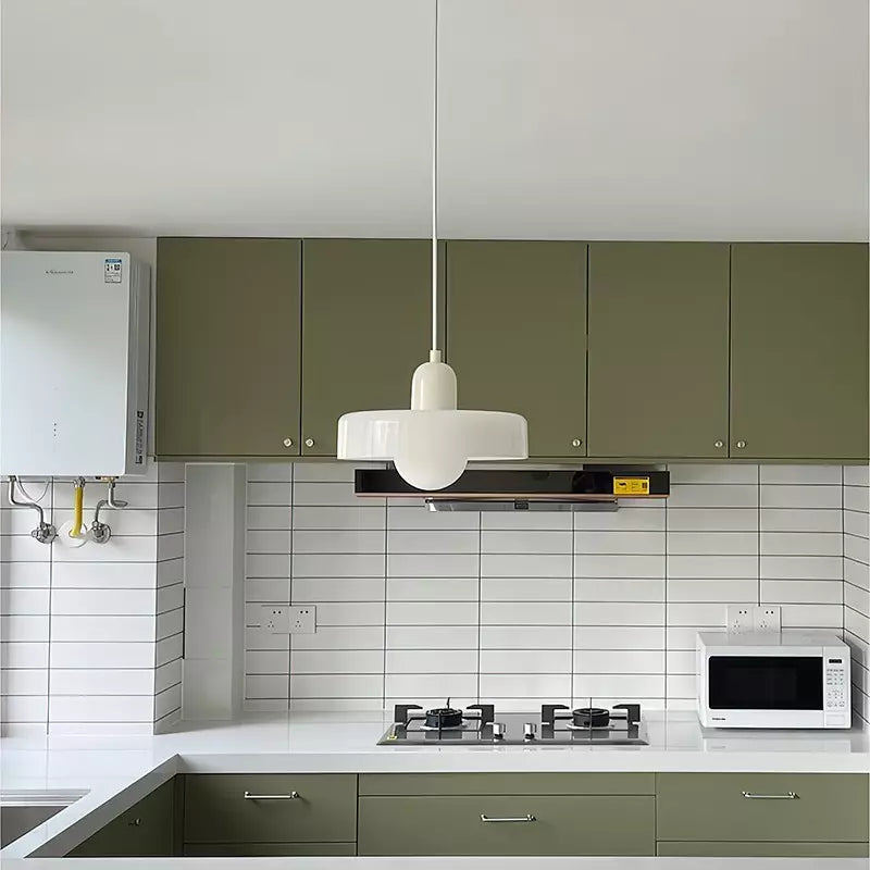White pendant lamp with a rounded cap hanging in a kitchen with olive green cabinets and white tile backsplash 47